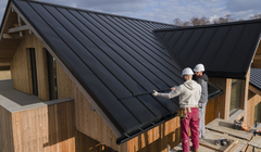 Wide thumb full shot roofers working together with helmets