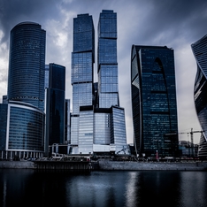 Thumb low angle shot grey skyscrapers front river dark cloudy sky